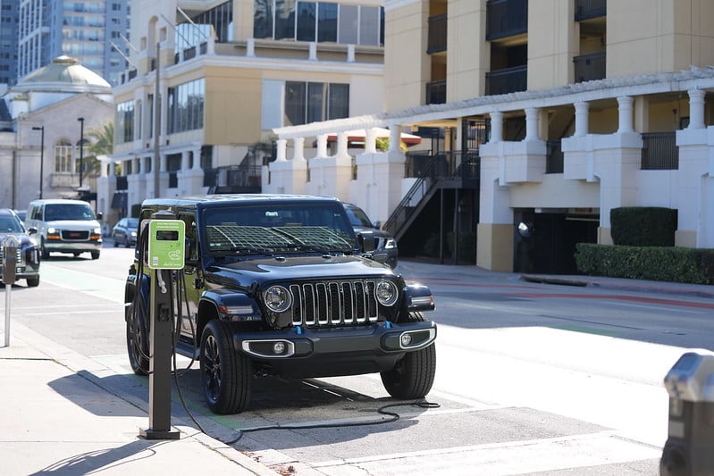 Black jeep using a novaCHARGE charger in outside on side street