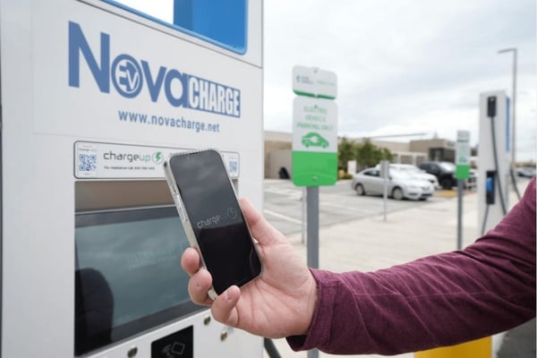 man uses EV Charging App at EV charging station 